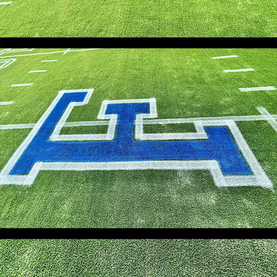 newly painted blue letter "F" on Texas football field